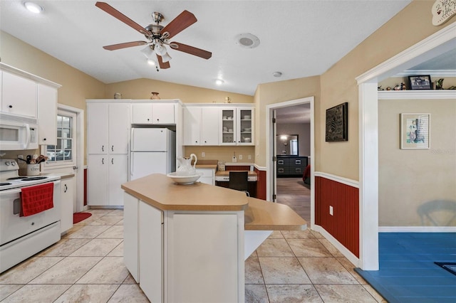 kitchen featuring vaulted ceiling, white appliances, white cabinets, and a kitchen island