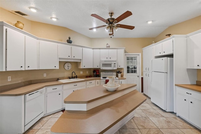 kitchen with white appliances, white cabinets, lofted ceiling, a kitchen island, and sink