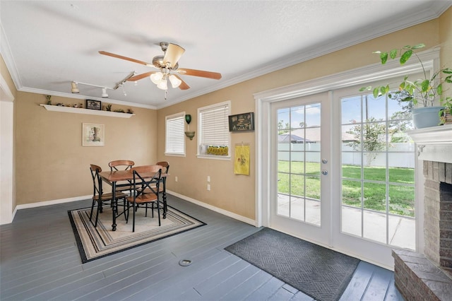 dining room featuring ceiling fan, dark hardwood / wood-style flooring, ornamental molding, and a fireplace