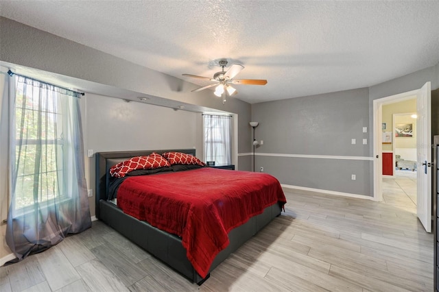 bedroom with ceiling fan and a textured ceiling