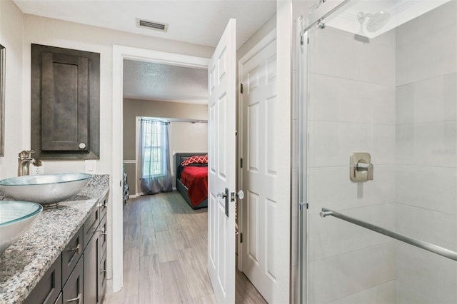 bathroom featuring vanity, hardwood / wood-style flooring, and an enclosed shower