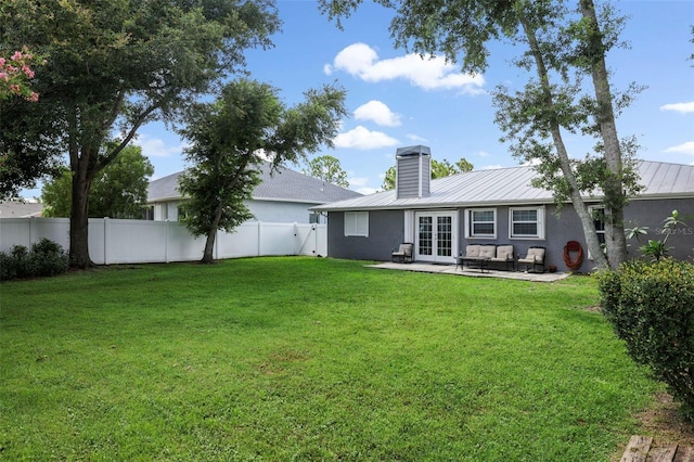 rear view of property with french doors, a patio, and a yard