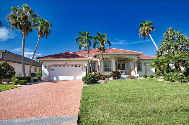 mediterranean / spanish home featuring a front yard, a porch, and a garage