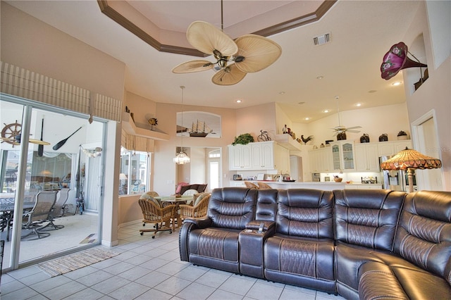 living room featuring a towering ceiling, ceiling fan, and light tile patterned floors