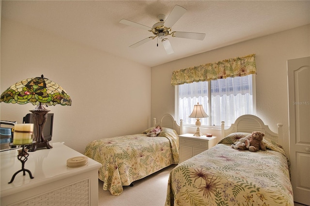 carpeted bedroom with a textured ceiling and ceiling fan