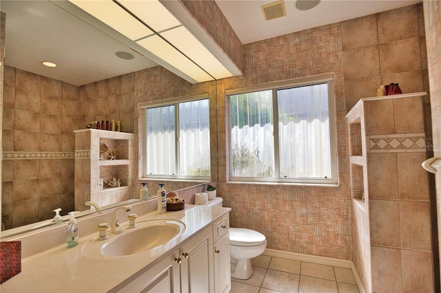 bathroom featuring toilet, vanity, tile patterned floors, and a healthy amount of sunlight