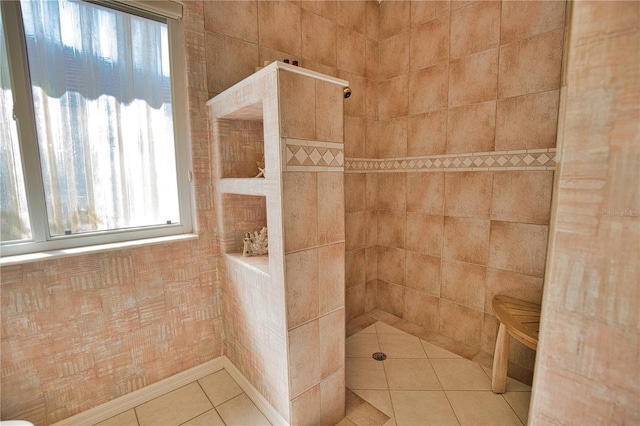 bathroom with tile patterned flooring and a tile shower