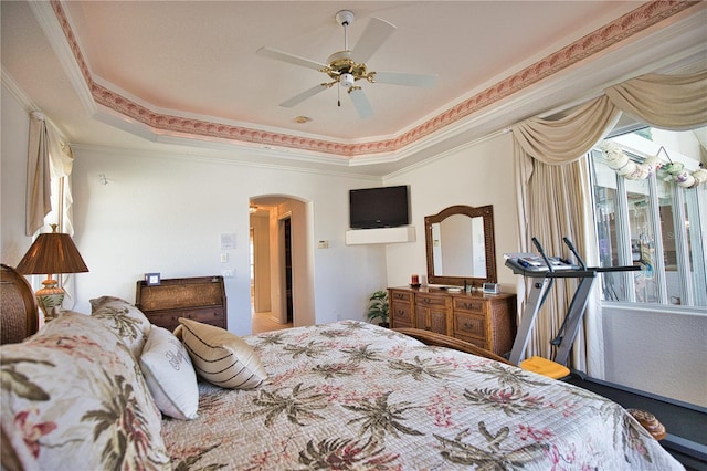 bedroom with ornamental molding, ceiling fan, and a raised ceiling