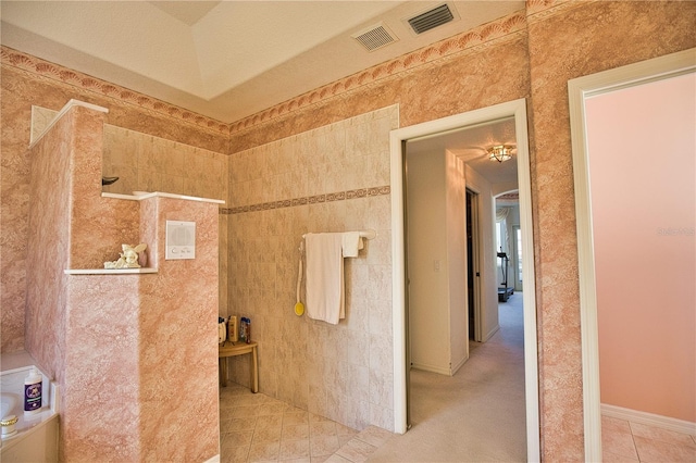 bathroom with a textured ceiling and tile patterned floors