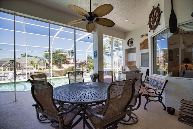 view of patio / terrace featuring ceiling fan, a grill, and glass enclosure