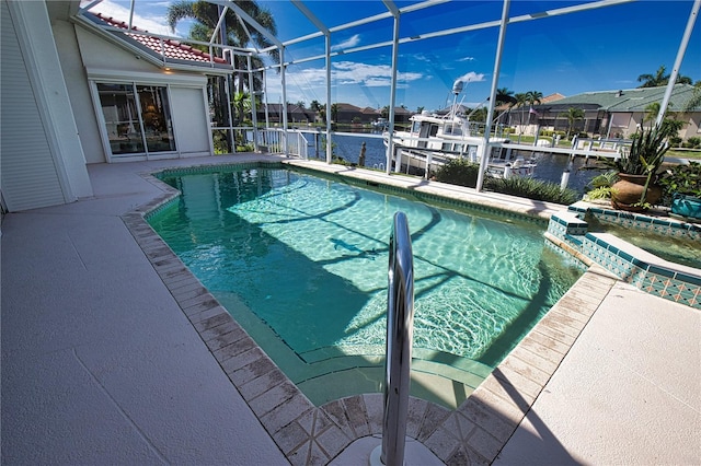 view of swimming pool with glass enclosure and a water view