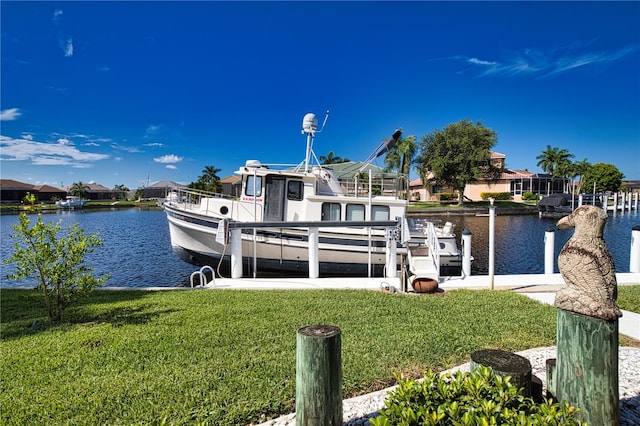 view of dock with a yard and a water view