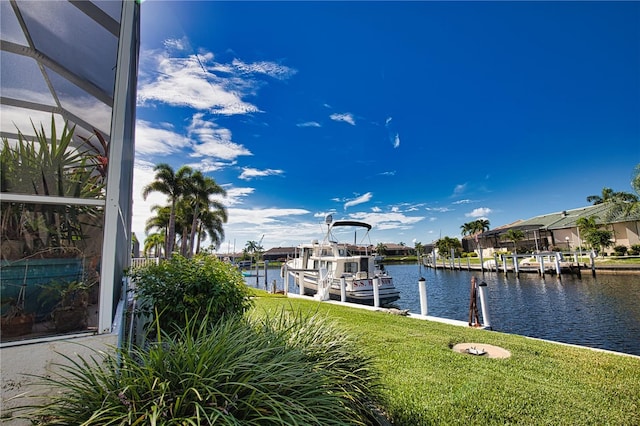 dock area featuring a lanai, a water view, and a yard