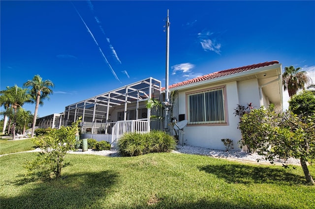 back of property featuring a lawn and a lanai