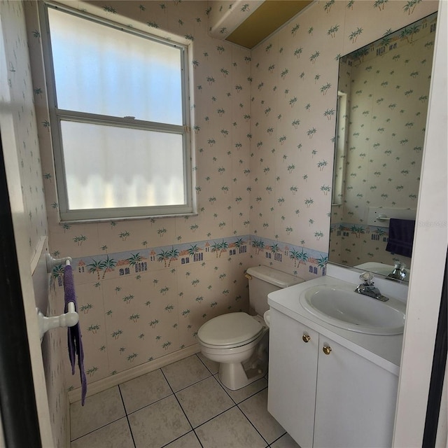 bathroom with toilet, vanity, and tile patterned floors