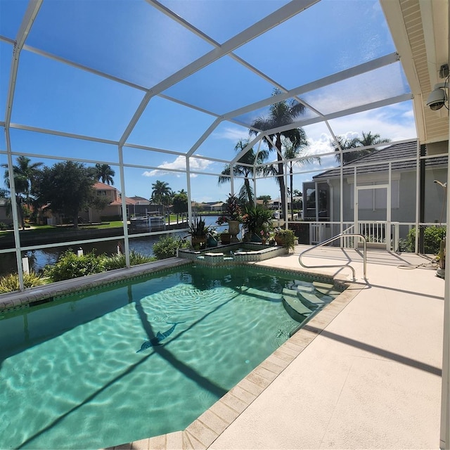 view of pool with a patio, glass enclosure, a water view, and an in ground hot tub