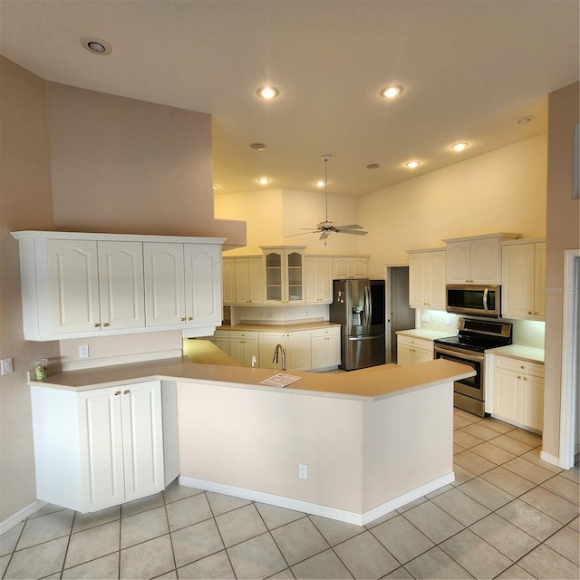 kitchen with white cabinets, stainless steel appliances, lofted ceiling, and sink