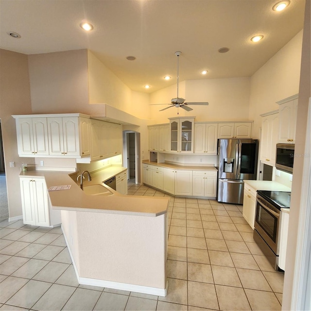 kitchen with stainless steel appliances, white cabinetry, high vaulted ceiling, sink, and kitchen peninsula