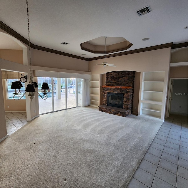 unfurnished living room with built in shelves, a fireplace, a textured ceiling, light tile patterned floors, and ceiling fan