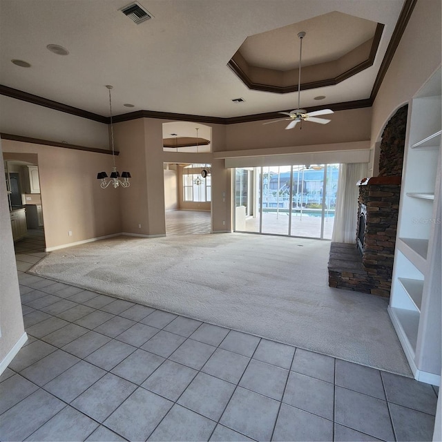 unfurnished living room featuring ornamental molding, ceiling fan with notable chandelier, light colored carpet, and a fireplace