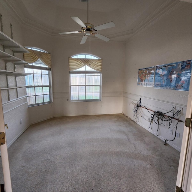 carpeted spare room featuring ceiling fan and crown molding