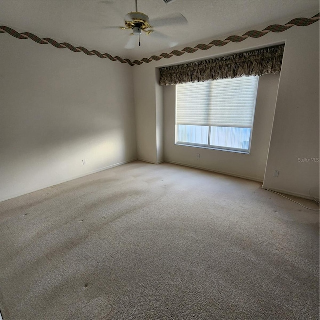 carpeted spare room with ceiling fan