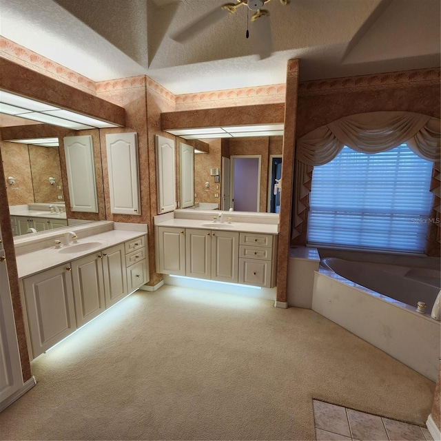 bathroom featuring a bathtub, vanity, a textured ceiling, and ceiling fan