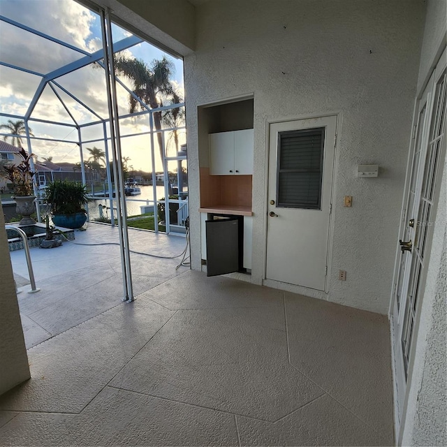 patio terrace at dusk featuring glass enclosure