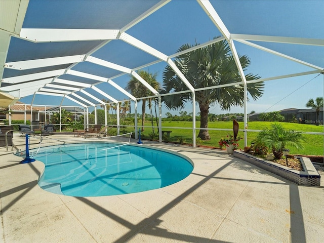 view of pool featuring a lawn, a patio area, and a lanai