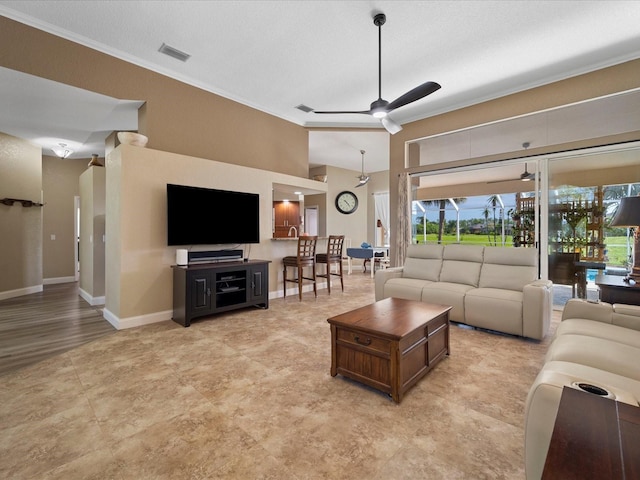 living room with a textured ceiling, ornamental molding, and ceiling fan