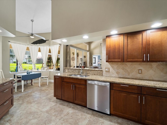 kitchen featuring sink, tasteful backsplash, dishwasher, ceiling fan, and light stone countertops