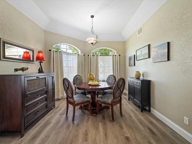 dining space featuring lofted ceiling and hardwood / wood-style floors