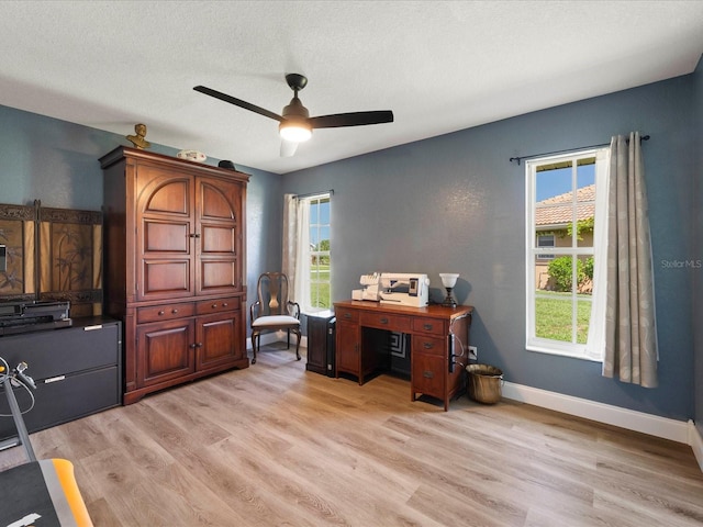 home office featuring ceiling fan, a healthy amount of sunlight, light hardwood / wood-style floors, and a textured ceiling