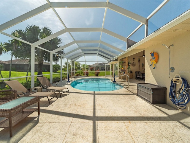 view of swimming pool with a yard, glass enclosure, and a patio area