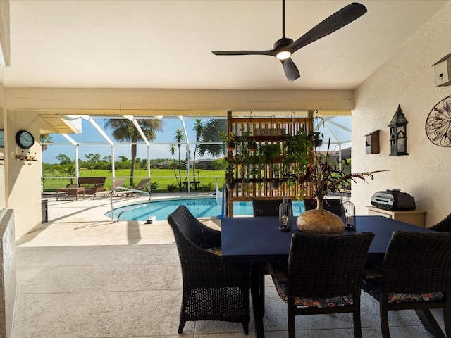 view of pool featuring a patio, ceiling fan, and glass enclosure