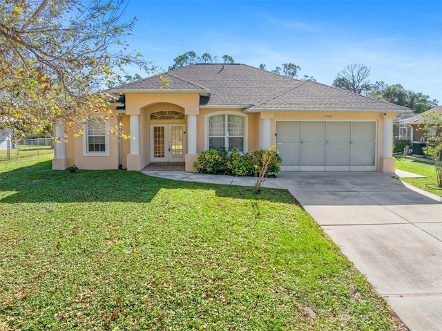 ranch-style house with a garage, a front yard, and french doors