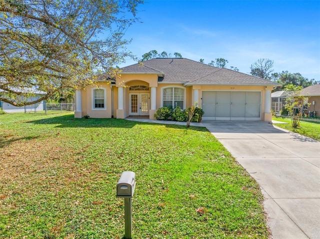 view of front of home featuring french doors, a garage, and a front yard