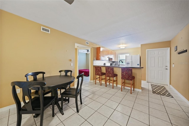 dining space with light tile patterned floors and sink