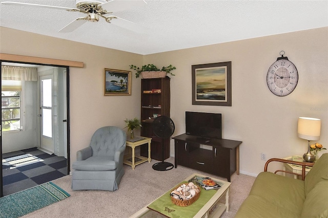 carpeted living room featuring a textured ceiling and ceiling fan