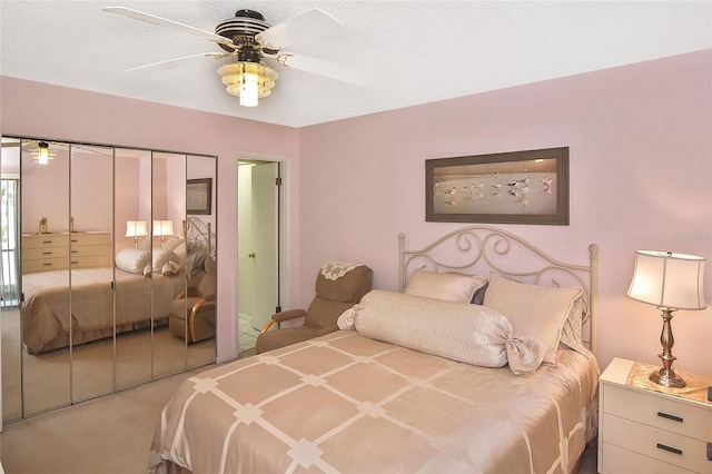 bedroom featuring a textured ceiling, a closet, carpet floors, and ceiling fan