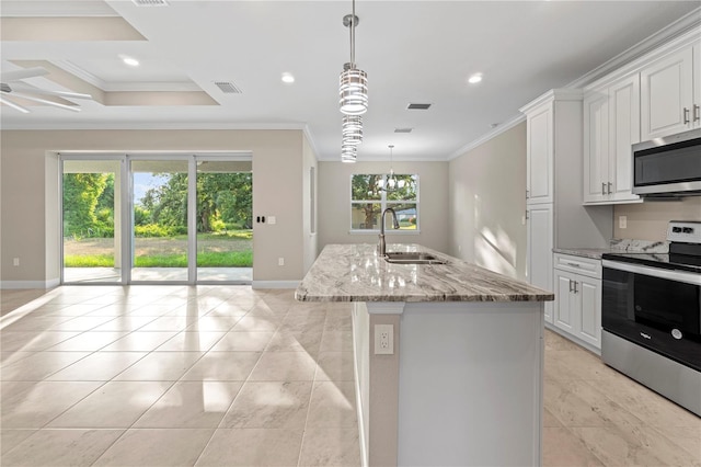 kitchen featuring sink, light stone countertops, an island with sink, appliances with stainless steel finishes, and plenty of natural light