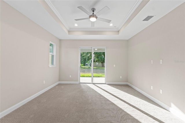 empty room with light carpet, a raised ceiling, ceiling fan, and crown molding