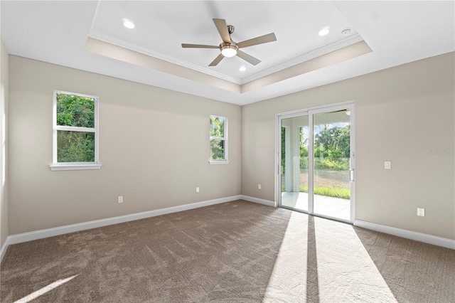 carpeted empty room with a tray ceiling, ceiling fan, and crown molding