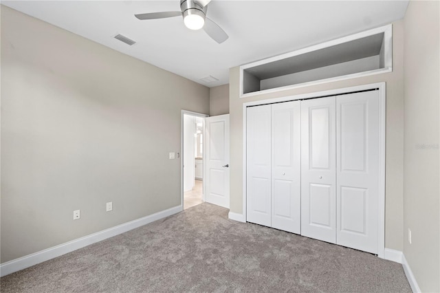 unfurnished bedroom featuring a closet, light colored carpet, and ceiling fan