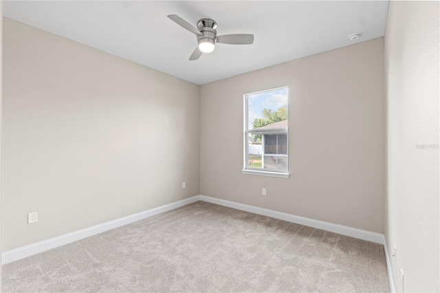 carpeted spare room with ceiling fan