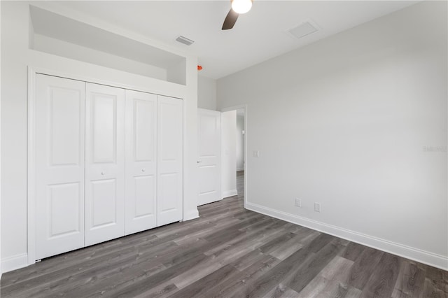 unfurnished bedroom with ceiling fan, visible vents, baseboards, a closet, and dark wood-style floors