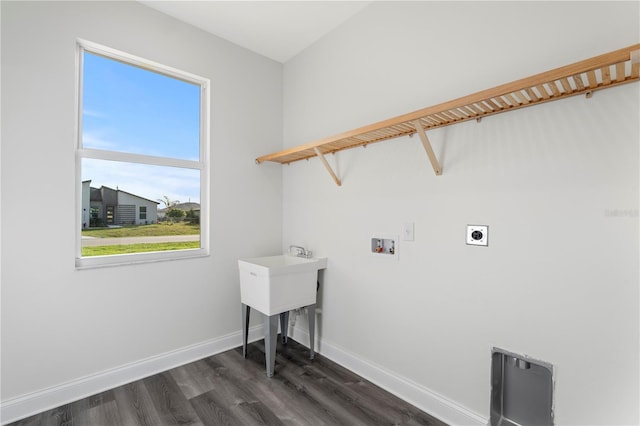 clothes washing area featuring dark wood finished floors, hookup for a washing machine, electric dryer hookup, laundry area, and baseboards