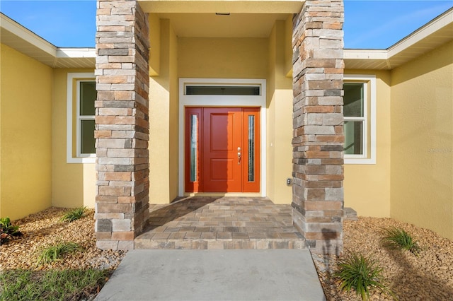 property entrance with stone siding and stucco siding