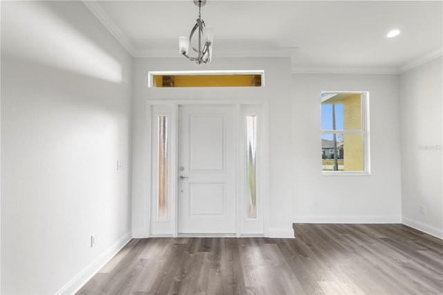 entryway featuring a chandelier, ornamental molding, dark wood-style flooring, and baseboards