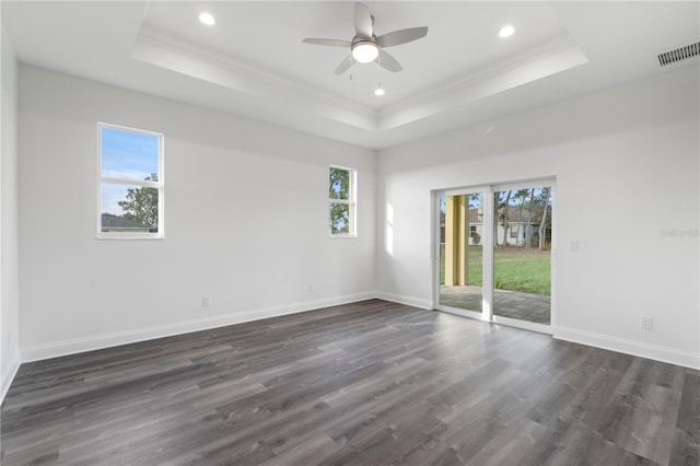 unfurnished room with dark wood-type flooring, a raised ceiling, and visible vents